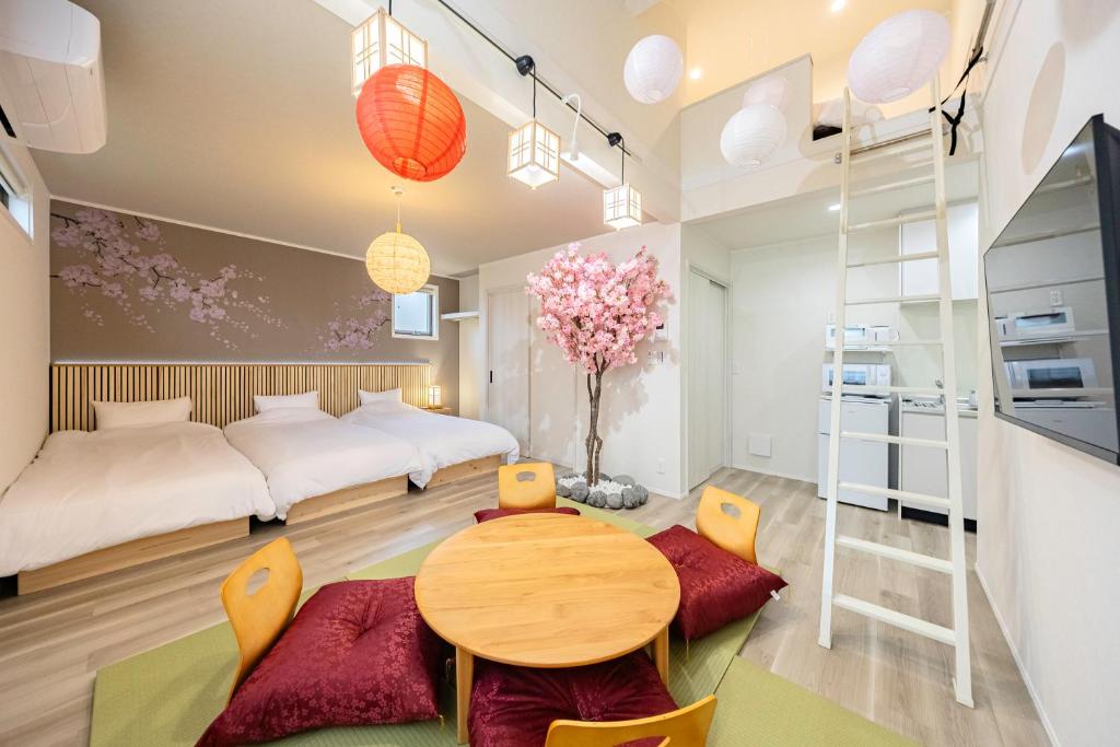 a room with two beds and a table and chairs at suite Funabashi SAKURA2 #202 in Funabashi