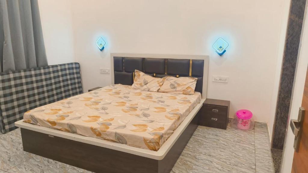 a bed in a bedroom with blue lights on the wall at Shree Karan Palace Family Guest House in Juliāsar