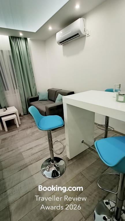 a room with a desk and two chairs and a couch at Apartman Mauna De Luxe in Bogatić