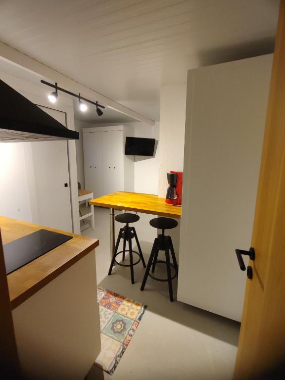 a kitchen with a yellow counter and two stools at Apartamento in Arona