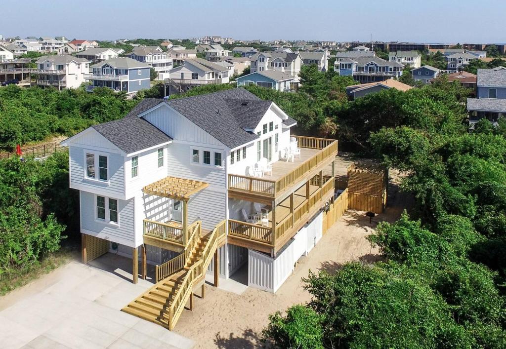 an aerial view of a white house with a deck at Sea Fever - Duck, Saltaire, 130 Yds to Beach, Ocean View, Pool, Hot Tub, Tiki Bar, Flex Stays in Duck