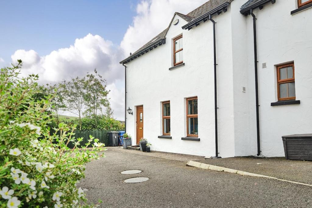 a white house with a driveway in front of it at Cappaghmore by Escape Ordinary in Portstewart