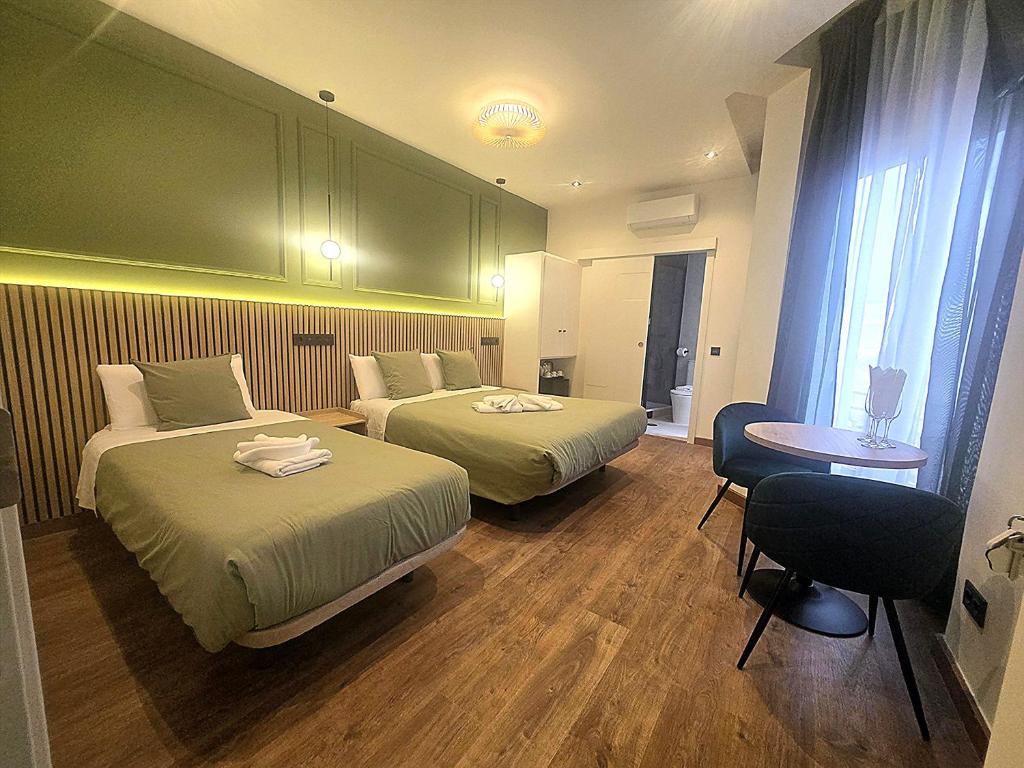 a hotel room with two beds and a table at Hostal Main Street Madrid in Madrid