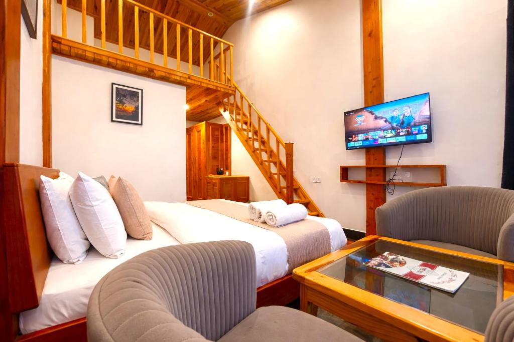 a hotel room with two beds and a tv at The Grand Dwaper A- Luxury Rooms & Parking Walking Distance From Mall Road in Mussoorie