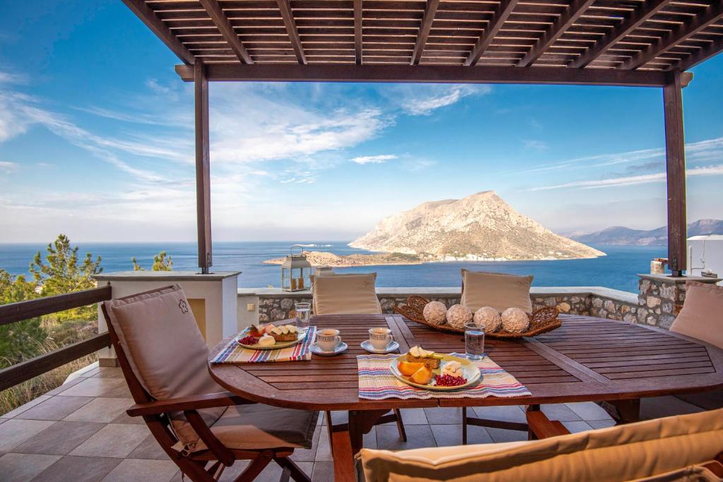 a table on a balcony with a view of a mountain at Sky & Sea View Retreat in Telendos