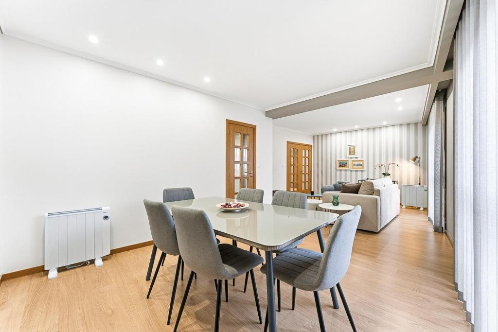 a dining room and living room with a table and chairs at GuestReady - Gaia Gardens Apartments in Vila Nova de Gaia