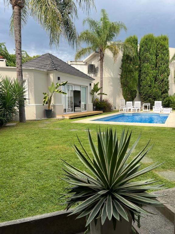 a house with a garden and a swimming pool at Blue House in San Pedro