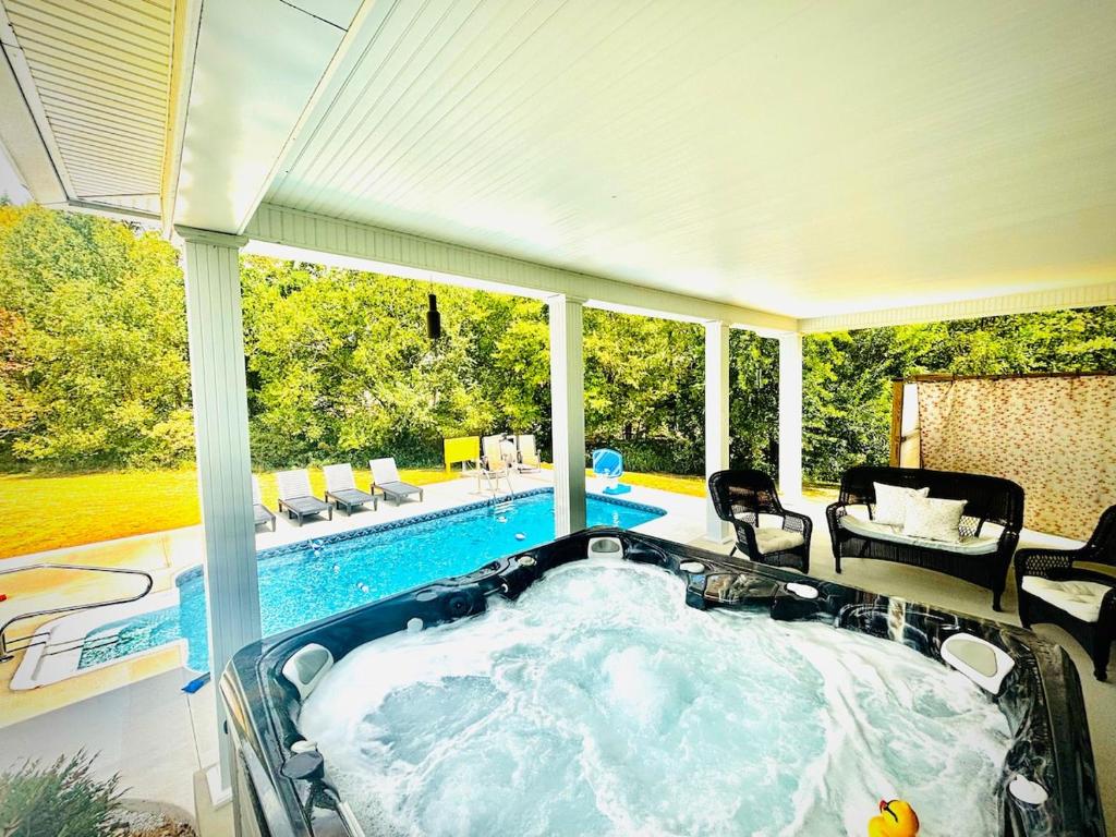 a jacuzzi tub in a house with a pool at Bourbon Trail Pool & Hot-Tub FUN-ZONE! Game Room! Pool Table! Golden Tee! Ping Pong! Luxurious and Spacious Master Bedroom! Fishing Offsite! in Springfield