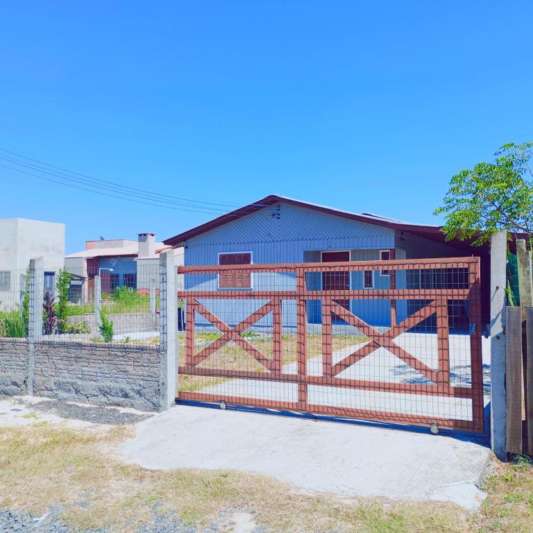a gate in front of a blue barn at Casa de verão vó judite -praia Sulmar- 4 quartos in Balneário Gaivotas