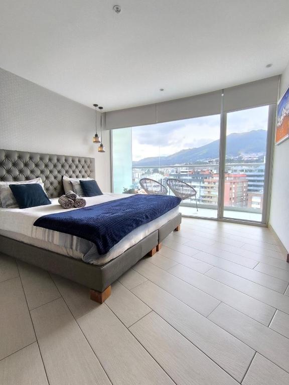 a bedroom with a large bed and a large window at ONE Luxury Suite Super King Bed & Volcano View in Quito