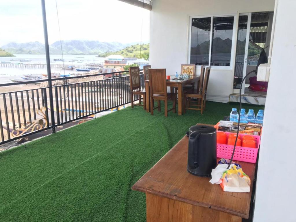 a balcony with a table and a view of the ocean at Homestay Jifiqa komodo in Komodo