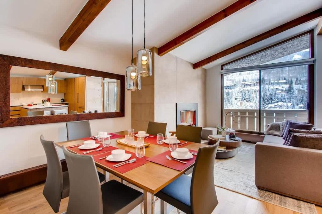 a dining room and living room with a table and chairs at Modern Vail Village Mountain View Residence in Vail