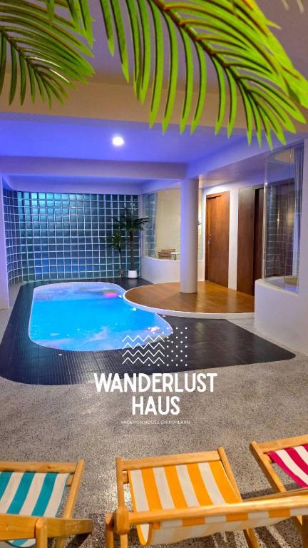 a room with a swimming pool and two chairs at Wanderlust HAUS in Ko Larn