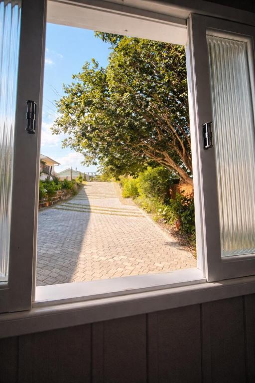 a window with a view of a brick road at ROTA DA SERRA casa completa com ar-cond in Orleans