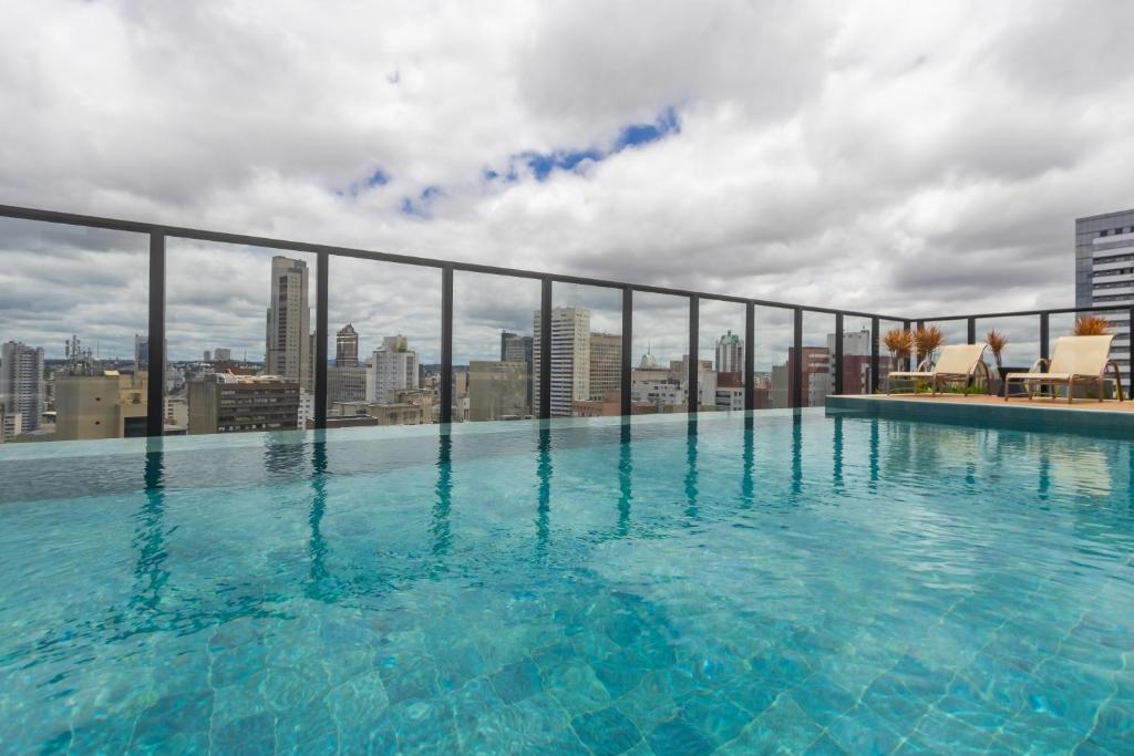 a swimming pool on the roof of a building at All Batel - Suyts in Curitiba