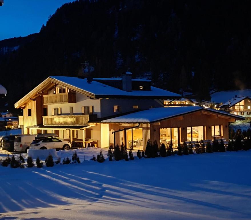 a house with snow on the ground in front of it at Chalet Dumbria Dolomites in Selva di Val Gardena