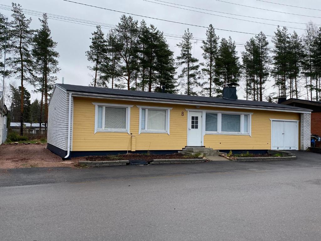 a yellow house sitting on the side of a street at Saunallinen iso omakotitalo in Kotka