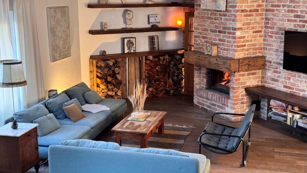 a living room with a couch and a fireplace at Dom w Przepitkach in Przepitki