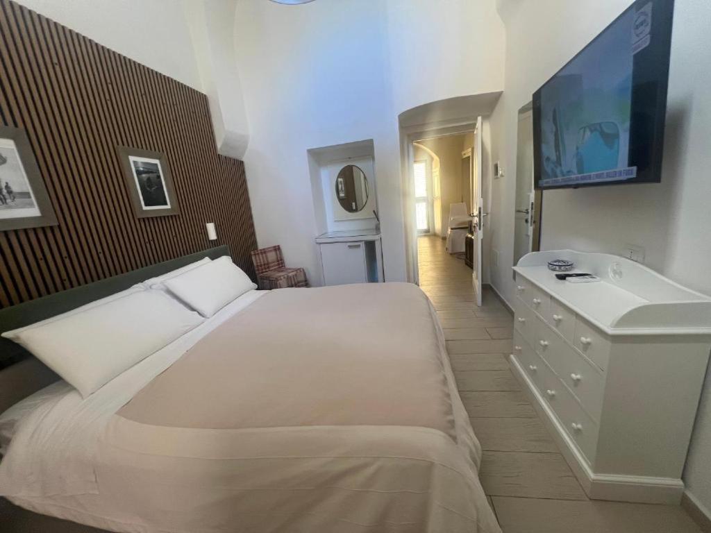 a bedroom with a large white bed and a sink at Elamar Apartments in Gallipoli