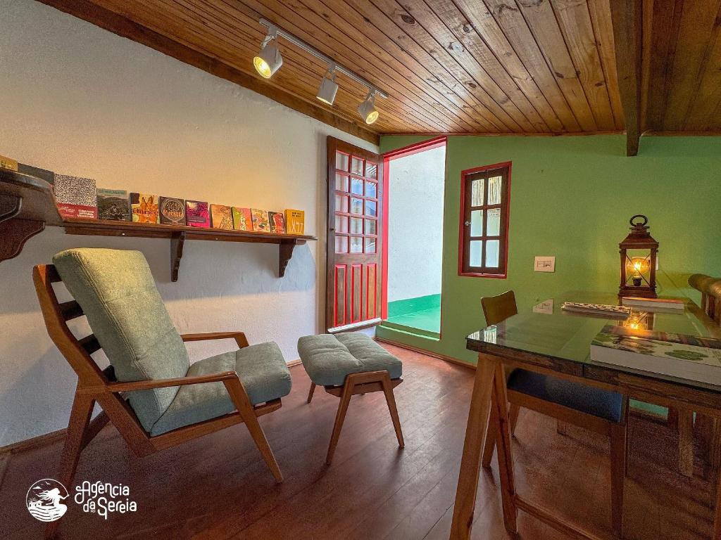 a room with a table and a chair and a desk at Chalés Canoa in Ilhabela