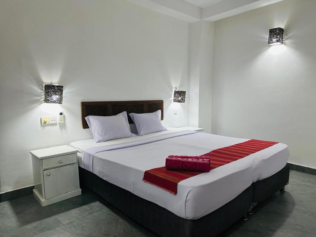 a bedroom with a large bed with a red blanket on it at inner pease in Nikawatawana