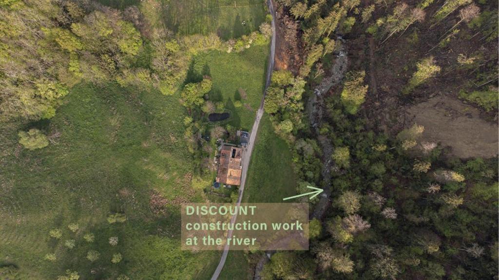 a house in a field with a sign that reads discount construction work at the river at Ferienwohnung im Grünen in Altstätten