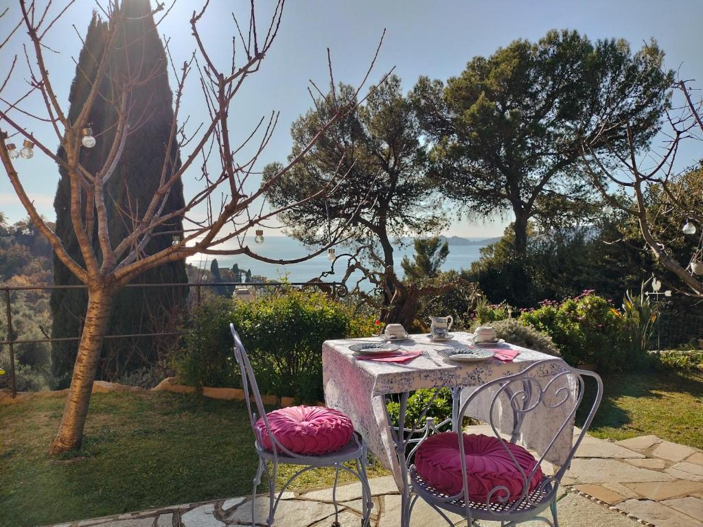 a table with two chairs with pink cushions on it at L'Alcova tra gli ulivi in Zoagli