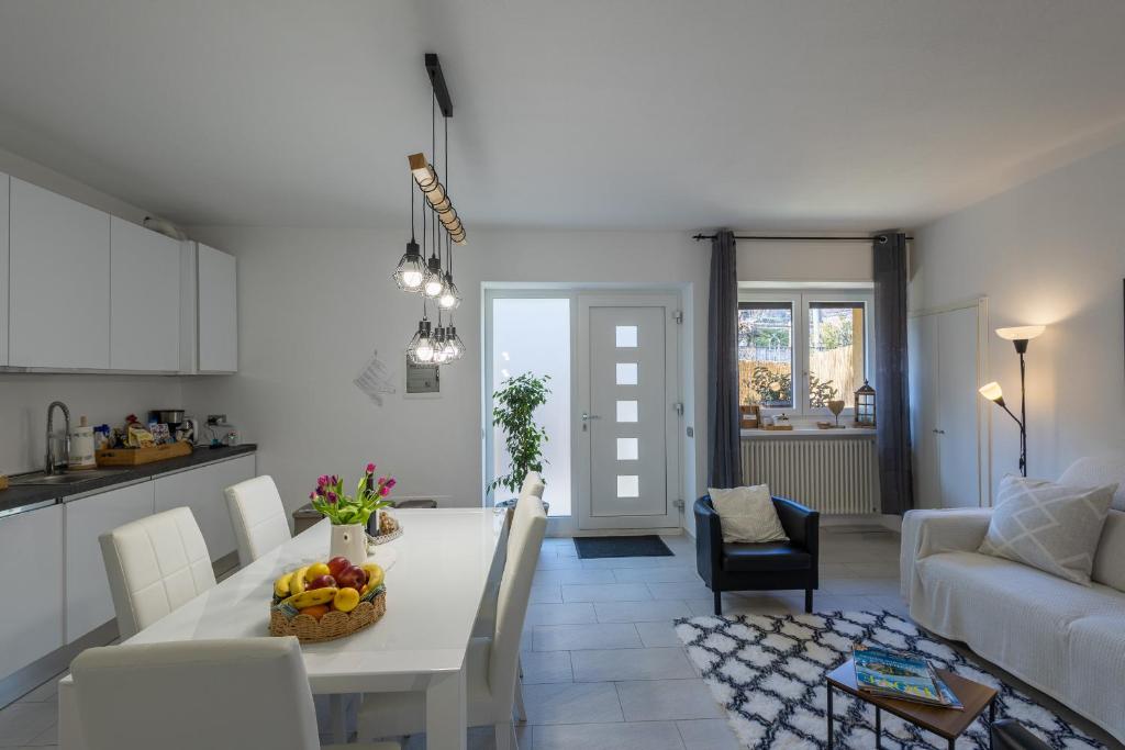 a kitchen and living room with a white table and chairs at LAKE COMO BORGO VIGNOLA - Cozy Apartment in a Charming Village in Cremia