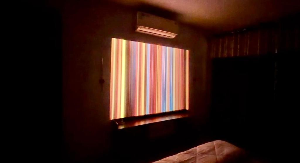 a window in a bedroom with a colorful curtain at La vida in Nalmatha