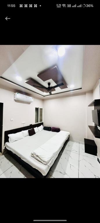 a bedroom with a white bed and a ceiling at Hotel Rainbow palace in Ujjain