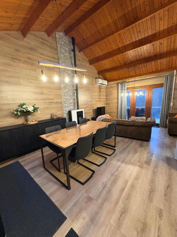 a dining room with a wooden table and chairs at Chalet La Vallée La Boverie in Rendeux