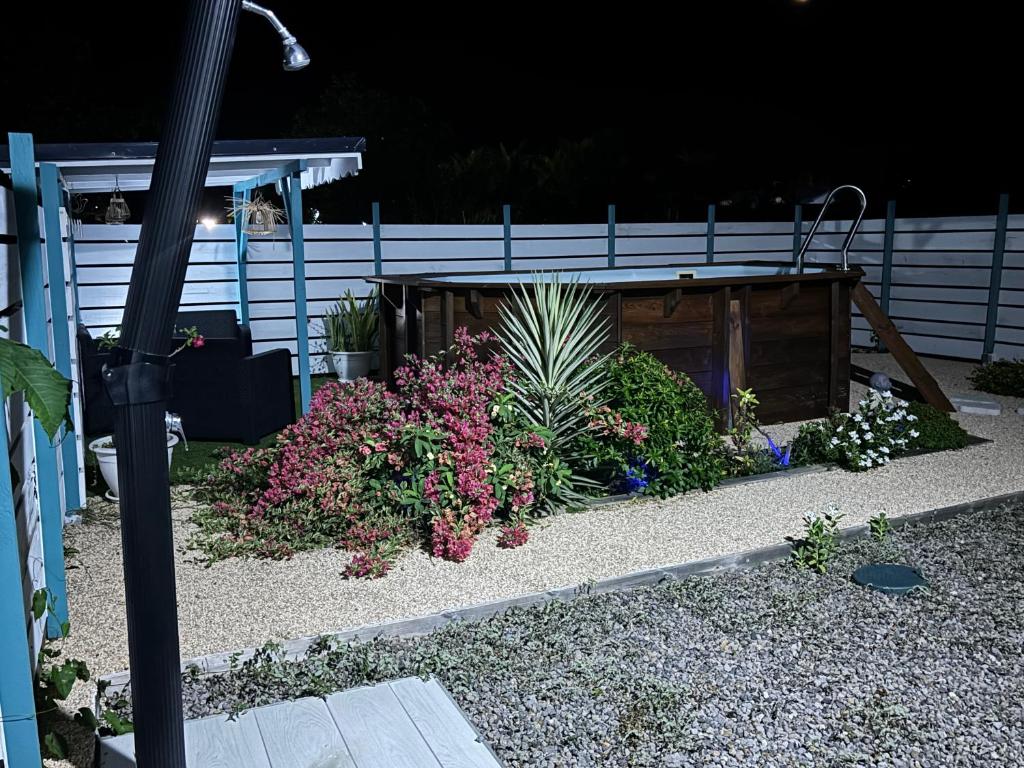 a garden with flowers and a wooden shed at Rêve Bleu in Capesterre