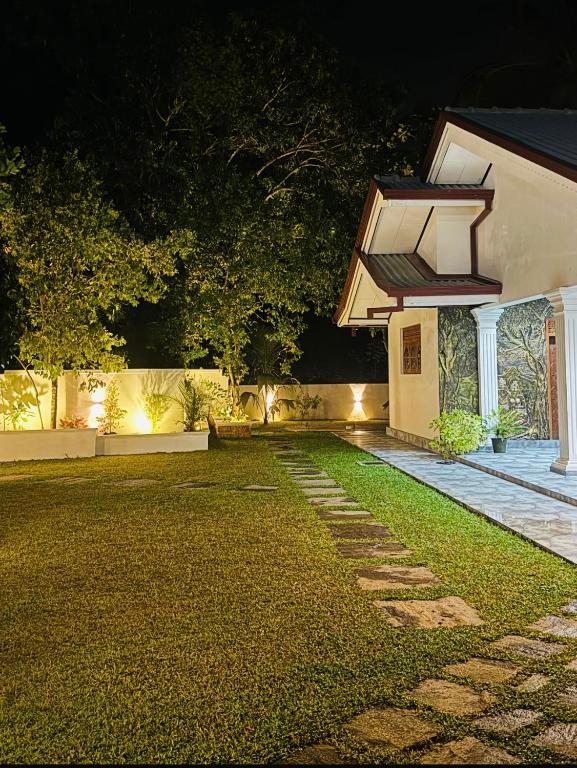 a backyard at night with a house with lights at Jasmine Breeze Villa in Kadawata