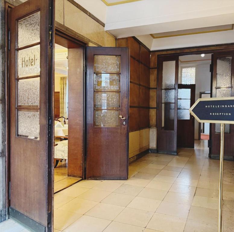 a hallway with doors and a sign in a building at Hotel Merkur in Zwickau