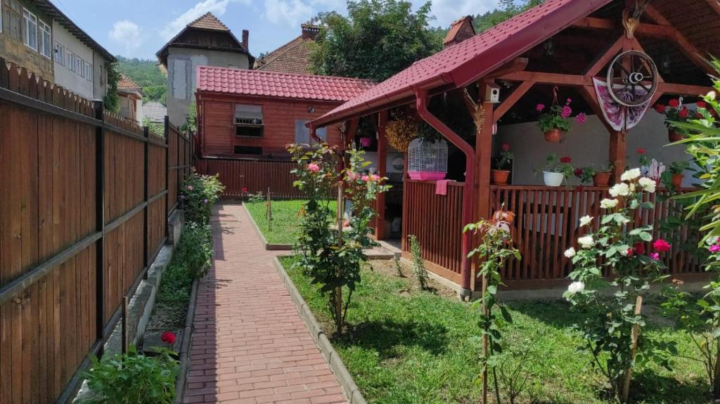 a garden with a fence and a house at Casa Foltea in Călimăneşti