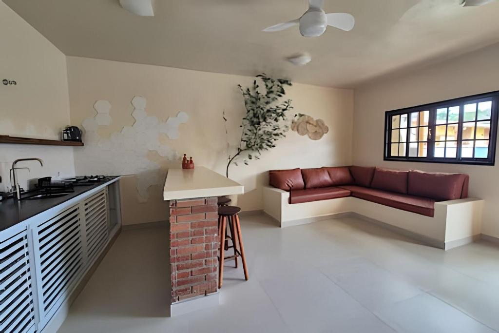 a kitchen and living room with a couch and a table at Vila Tero 400 metros da praia de Boraceia in São Sebastião