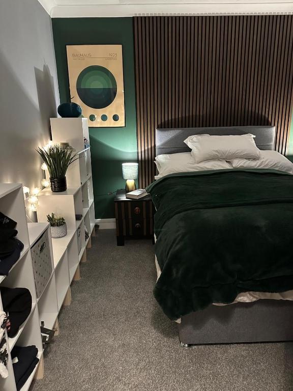 a bedroom with a bed and a green wall at Bungalow 44 - The Norfolk Broads At Your Door in Lowestoft