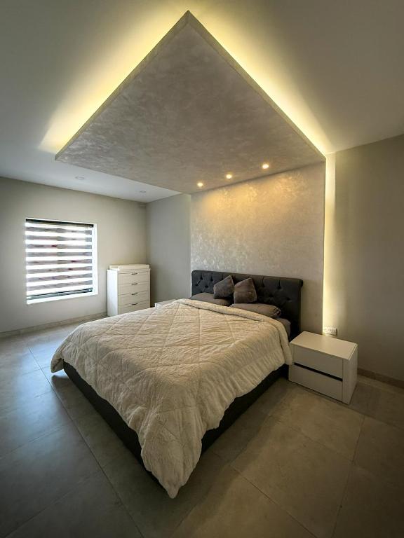 a bedroom with a large bed in a room at Bright Modern Apartment with Rooftop in Mqabba