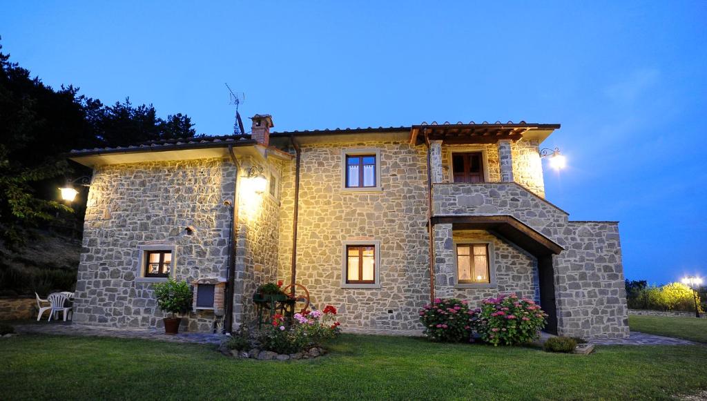 a stone house with flowers in front of it at Podere il Corniolino in Poppi