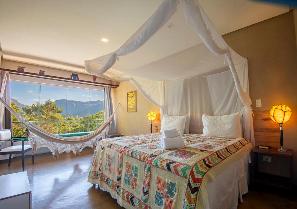 ein Schlafzimmer mit einem Himmelbett, auf dem ein Laptop steht in der Unterkunft Pousada do Capão Chapada Diamantina in Vale do Capao