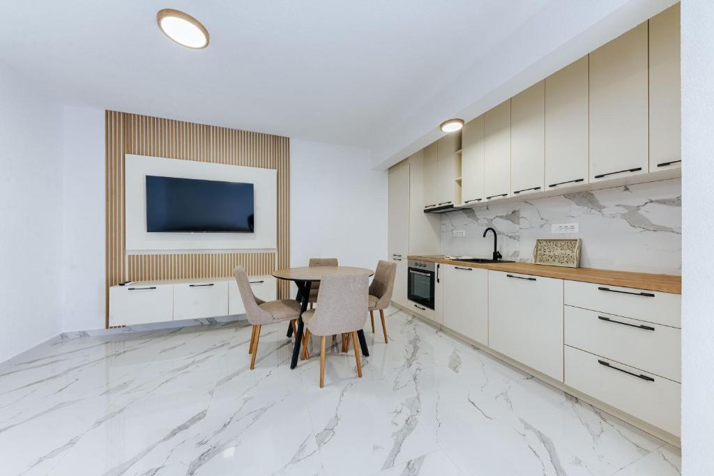 a kitchen with white cabinets and a table with chairs at Malik Bay RESIDENTS in Bar