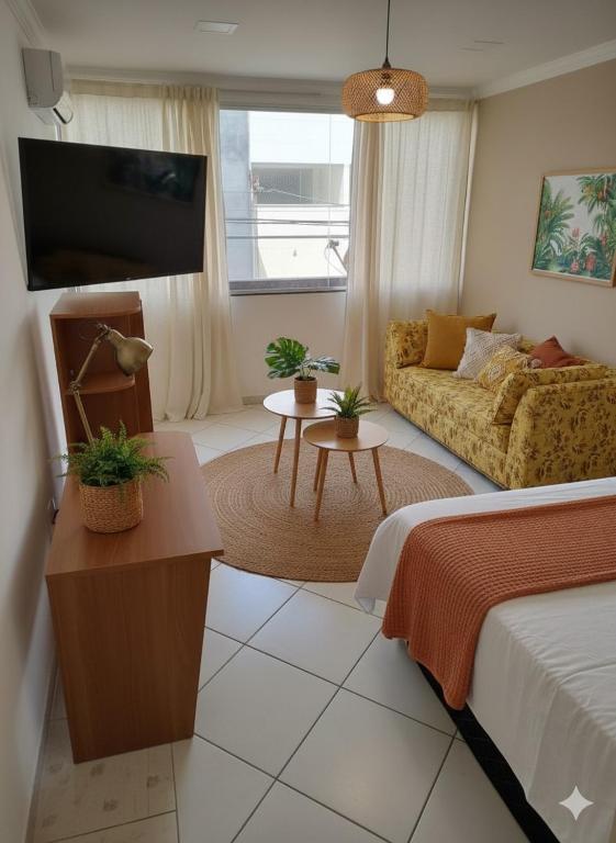 a living room with a bed and a couch at Copacabana Stay in Serra