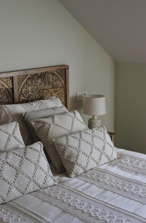 a bedroom with a bed with pillows and a lamp at El Mirador del Susarón in Puebla de Lillo