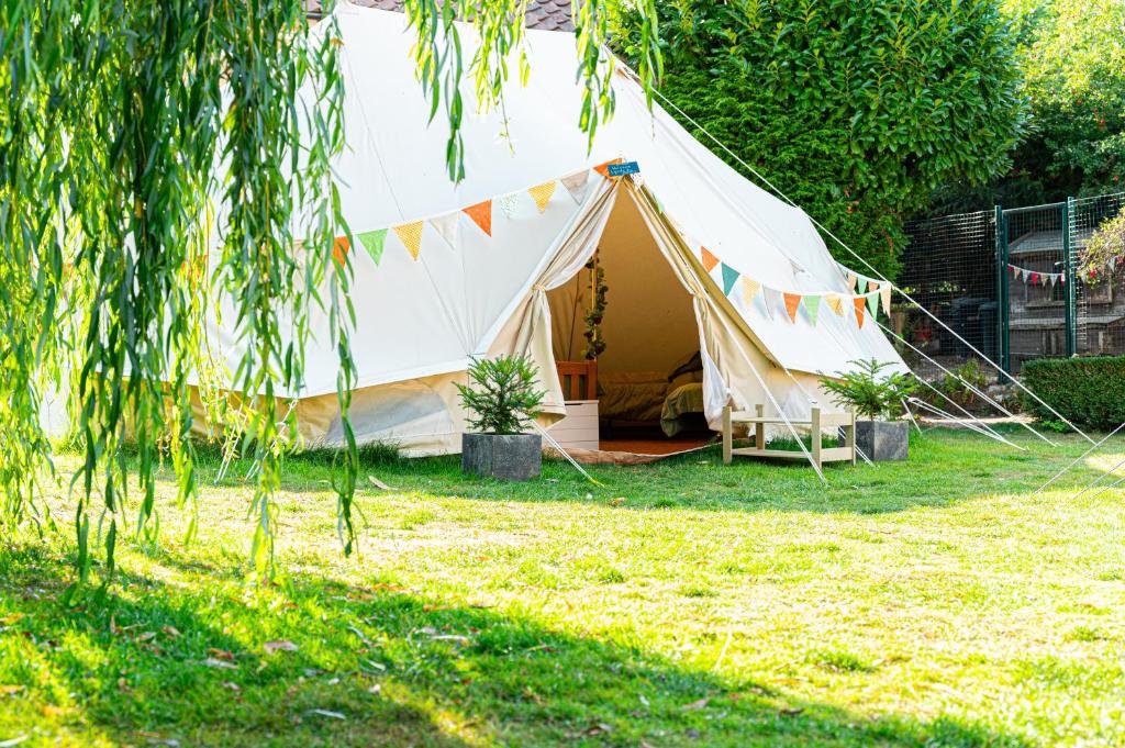 a tent in a yard with plants and flags at Aldwark Bridge Glamping - Aurora Tent in Aldwark