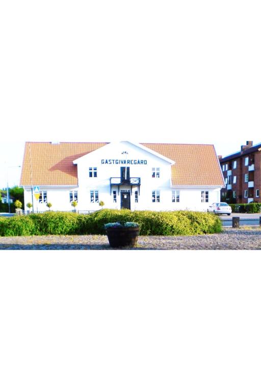 a white building with a sign on the front of it at Gästis lägenhet Örkelljunga in Orkelljunga