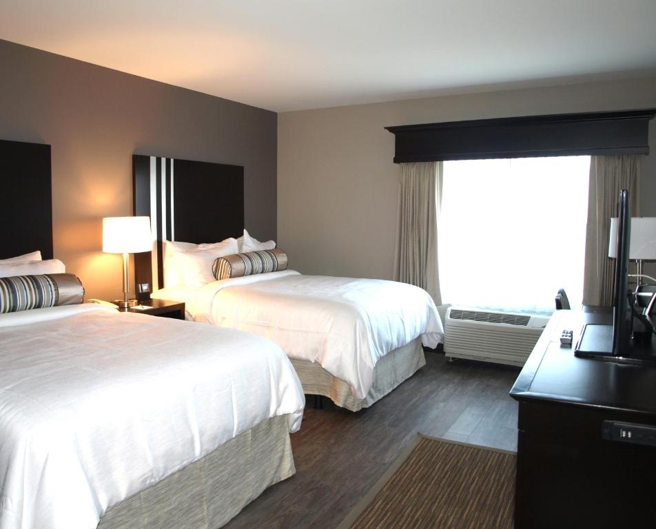 um quarto de hotel com duas camas e uma janela em Hotel at Batavia Downs em Batavia