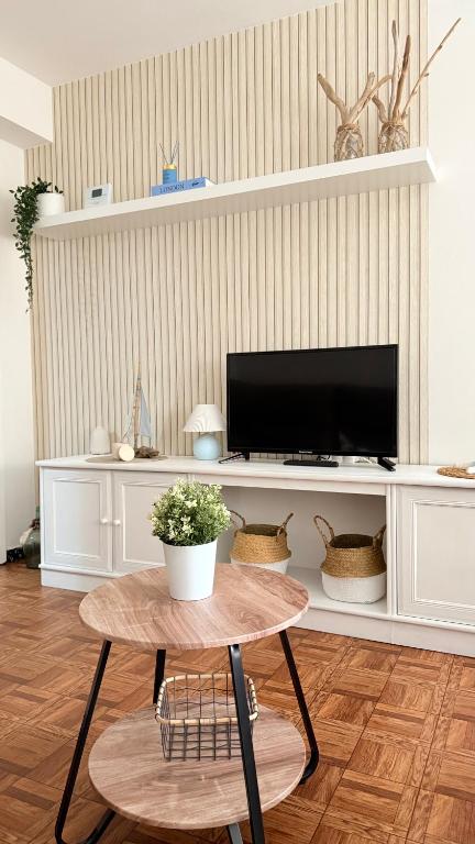 a living room with a table and a tv at A beira do Mar in Bueu