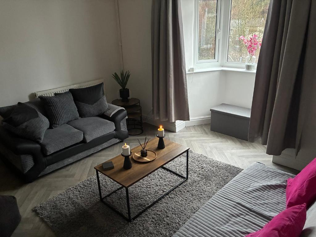 a living room with a couch and a table with a candle at Flat in Pont y Rhyl in Pont y Cymmer