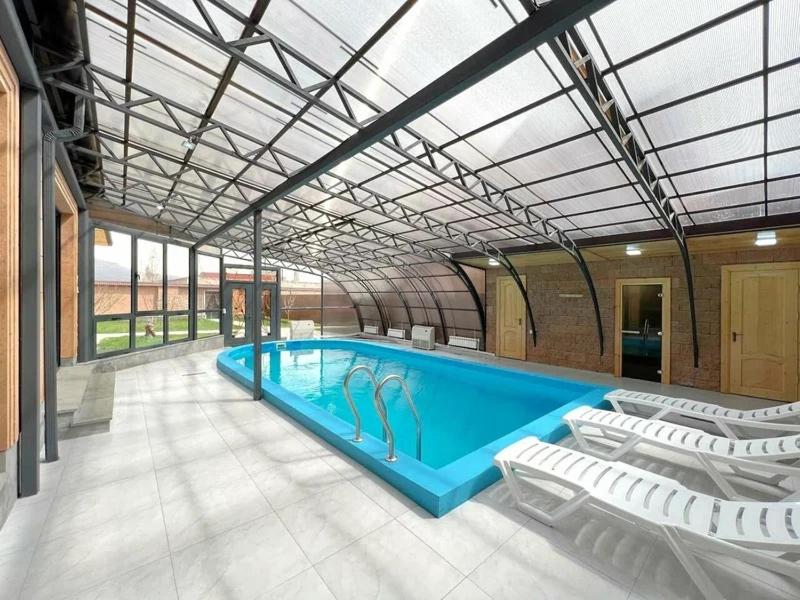 a swimming pool in a building with chairs around it at Home Comfort in Kotaykʼ
