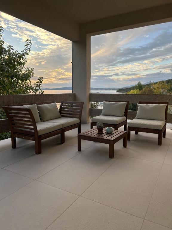 a patio with two benches and a table with pillows at Zara 1 in Kruševo